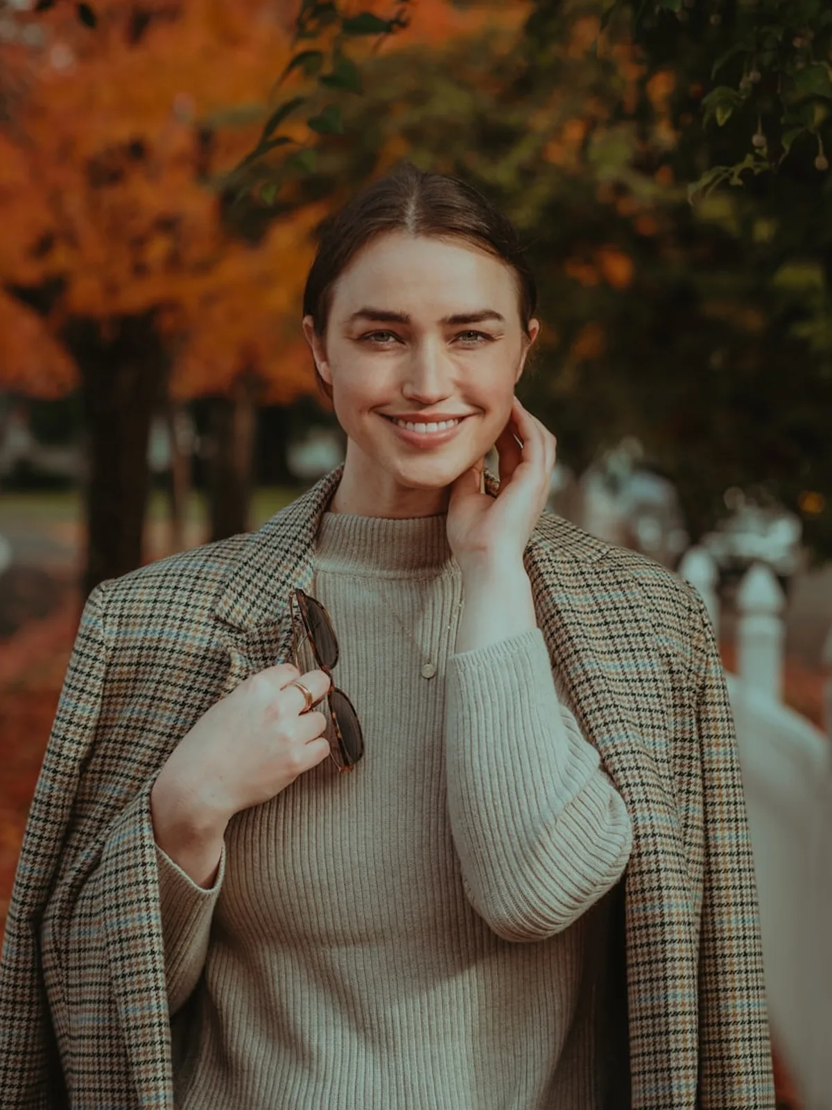 Woman in a tailored camel blazer, editorial portrait in warm light
